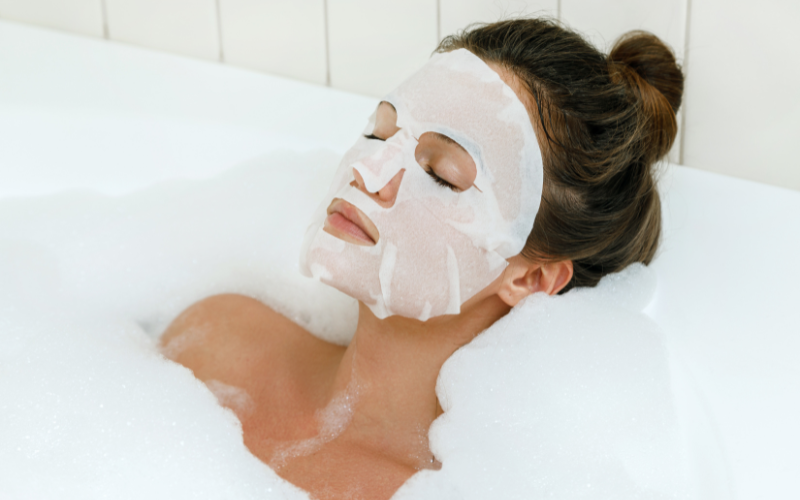 woman with face mask in bathtub relaxing