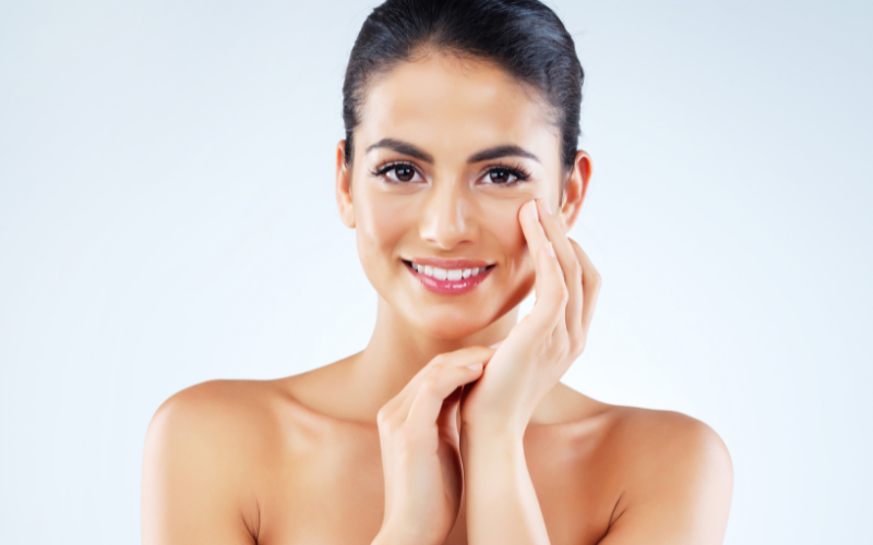 smiling brown woman hand on face looking in camera