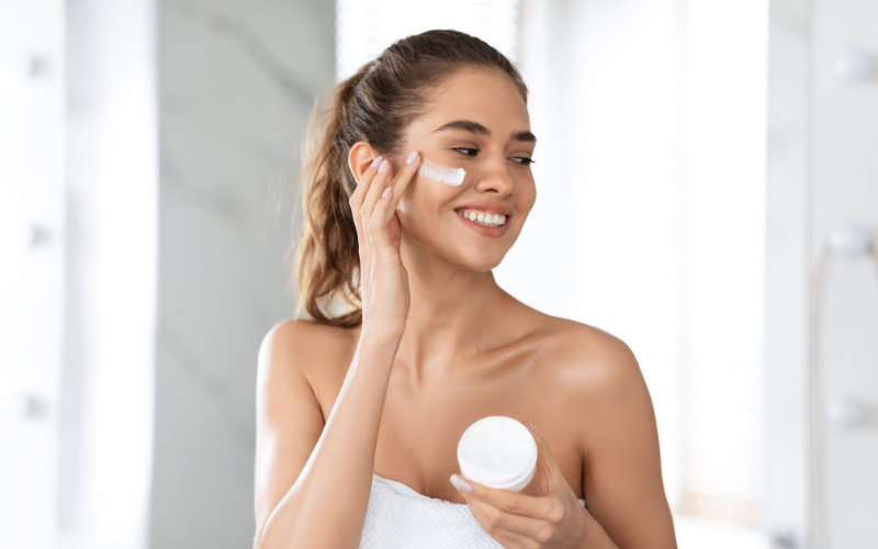 girl applying cream on face