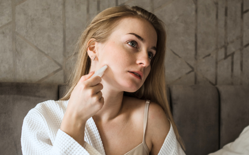 girl applying Gua Sha on collarbone