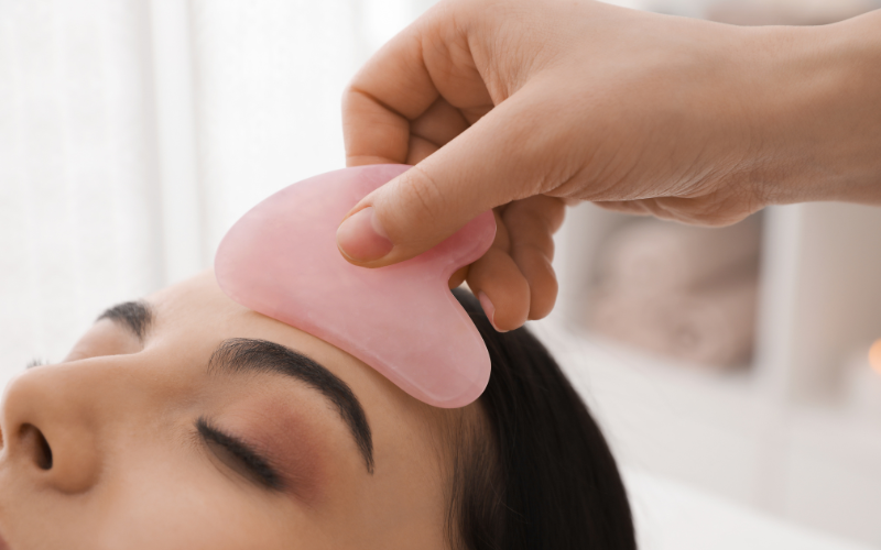 girl applying Gua Sha on face