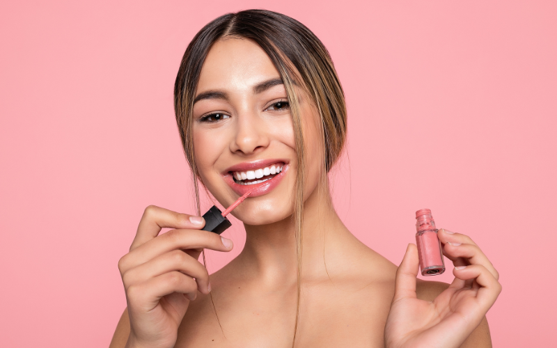 girl applying Nude or Bright Lipstick