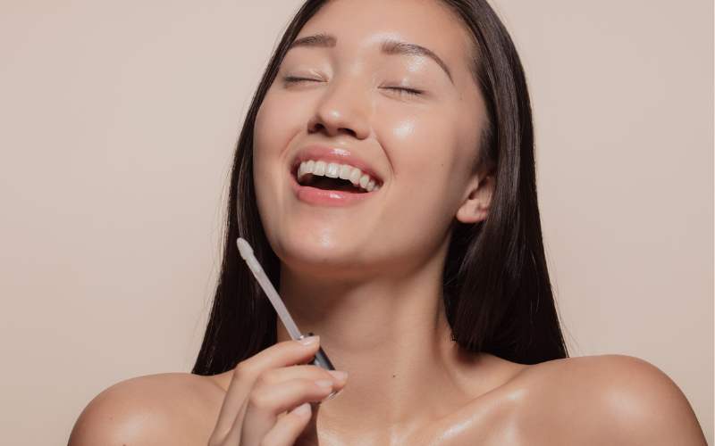 girl applying Lip Gloss on lips