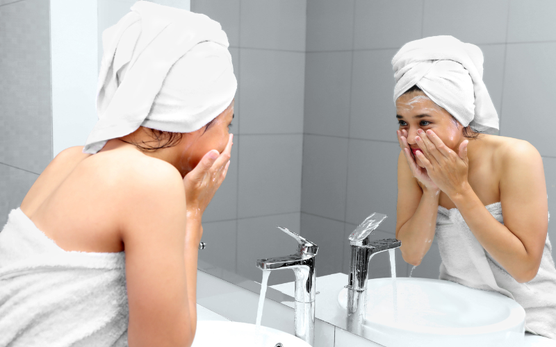 girl cleaning face with facewash and water