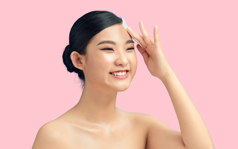 smilling girl removing extra oil from face