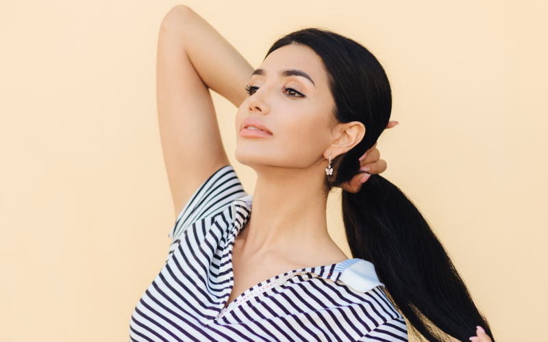 white woman posing with pony tail to camera, studio