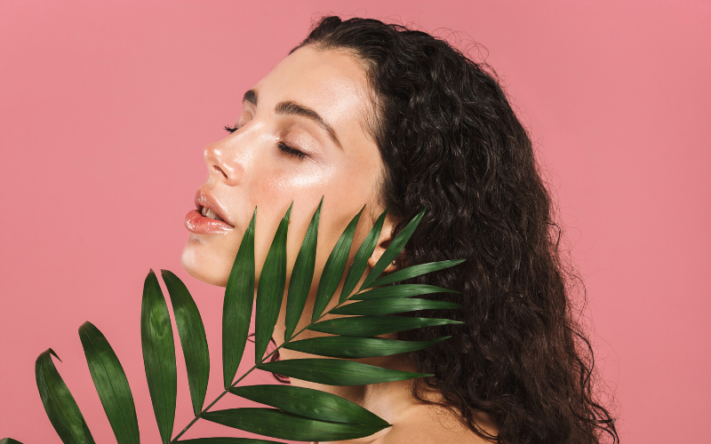 girl with green leaf and closed eyes feeling relaxed