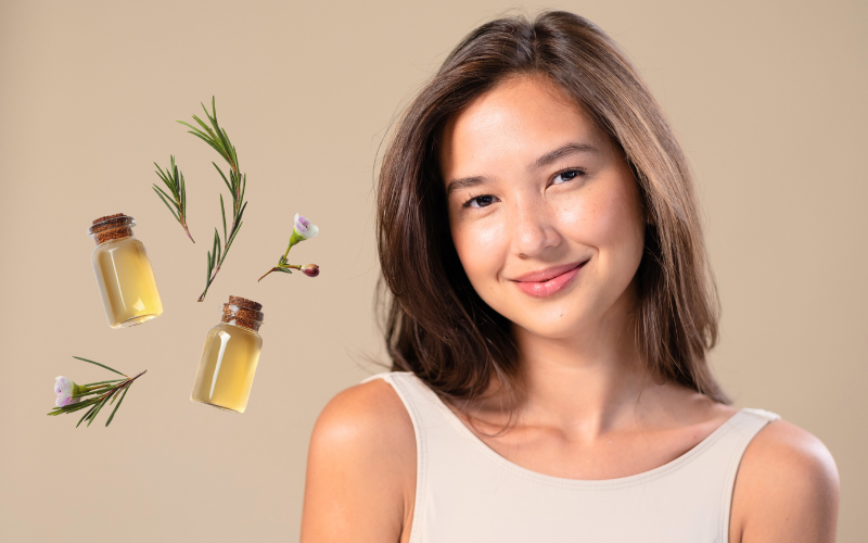 smiling asian woman looking in camera, tea tree oil on left