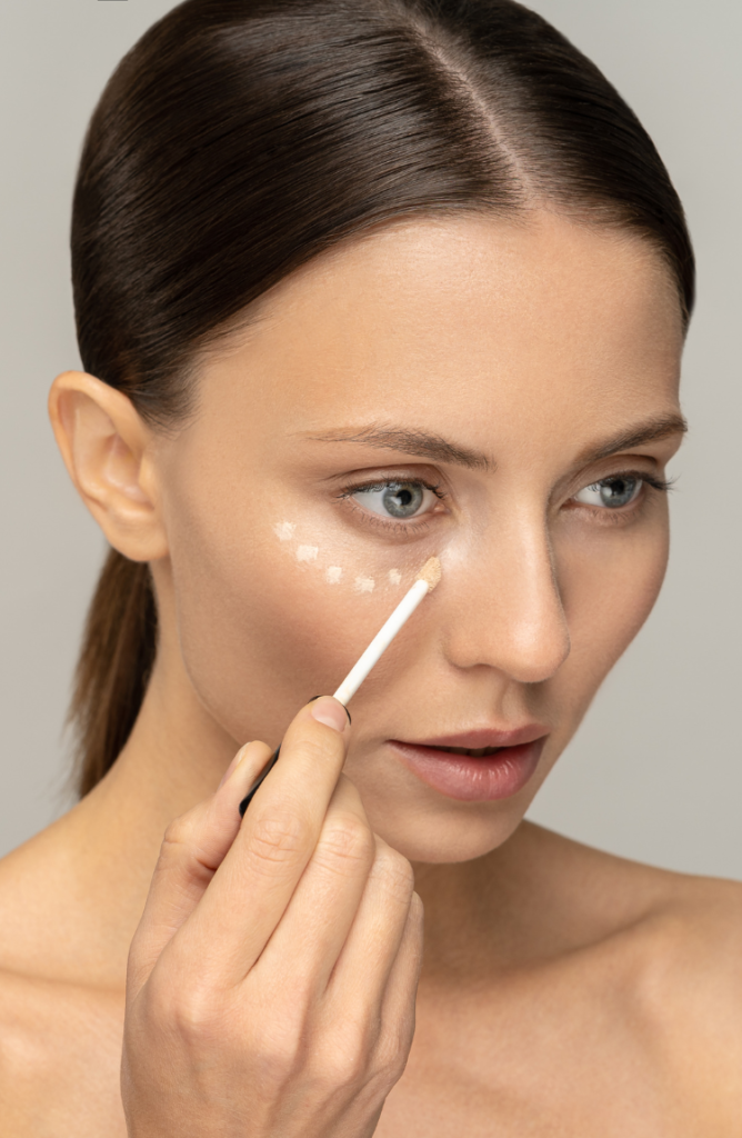 girl applying foundation under eyes Spot Conceal