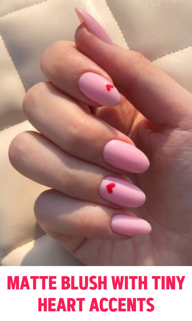 Matte blush pink nails with tiny red heart accents 