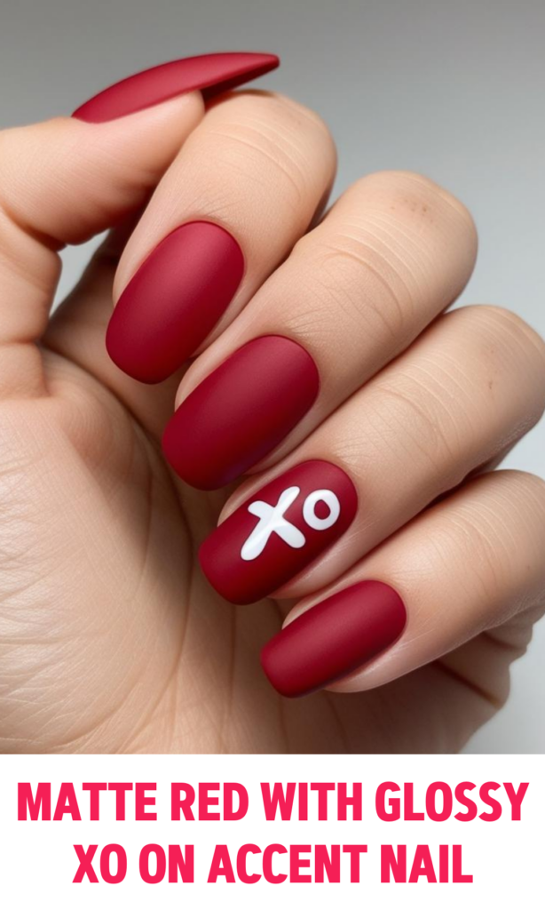 Matte red nails with a glossy XO pattern on ring finger